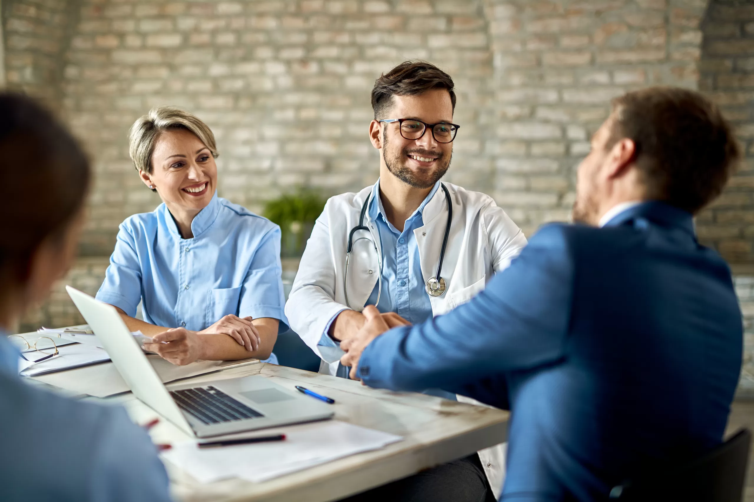 group healthcare workers greeting financial advisor meeting office focus is young doctor scaled Leading Healthcare Consulting Across Ghana