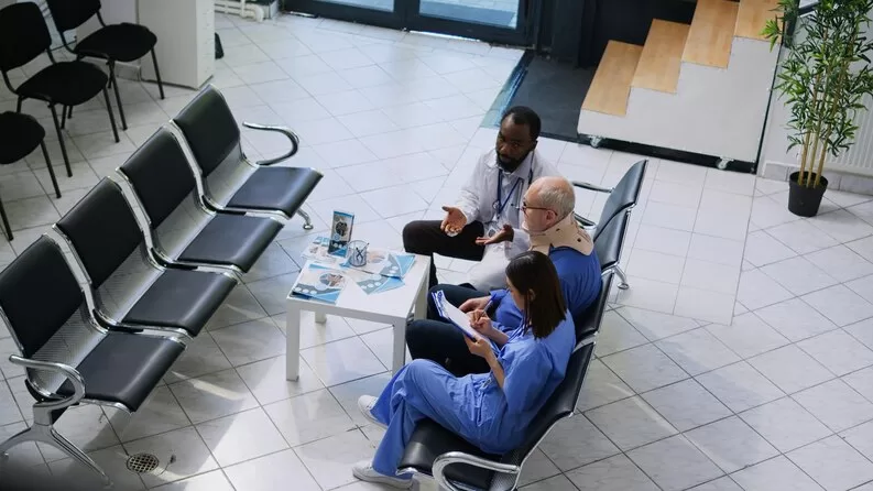 freepicdownloader.com doctor patient sit waiting room one them is wearing scrubs other is wearing blue scrubs medium Leading Healthcare Consulting Across Burundi