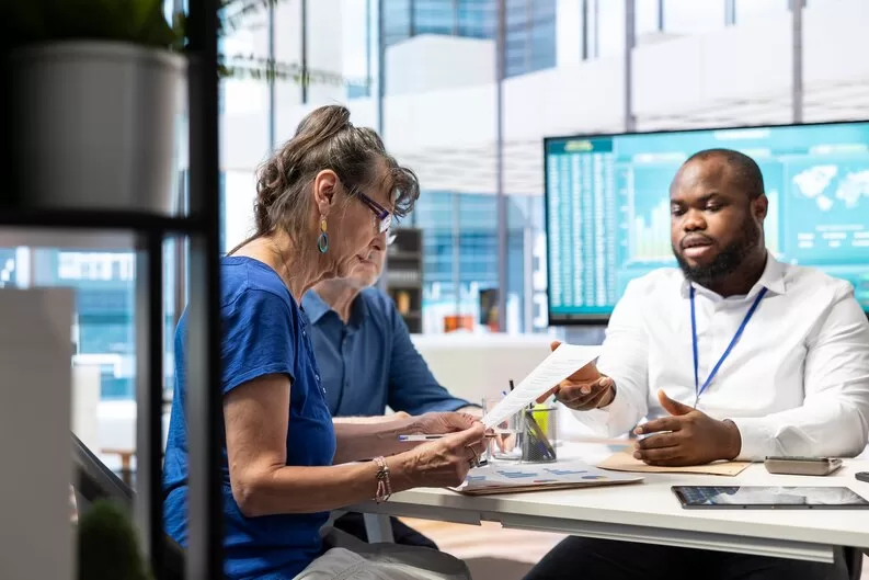 freepicdownloader.com senior person signs financial investment contract discussion with banker medium Leading Healthcare Consulting Across Uganda